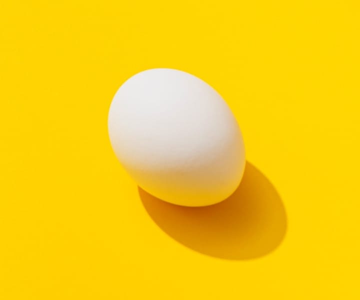 A white egg with yello background