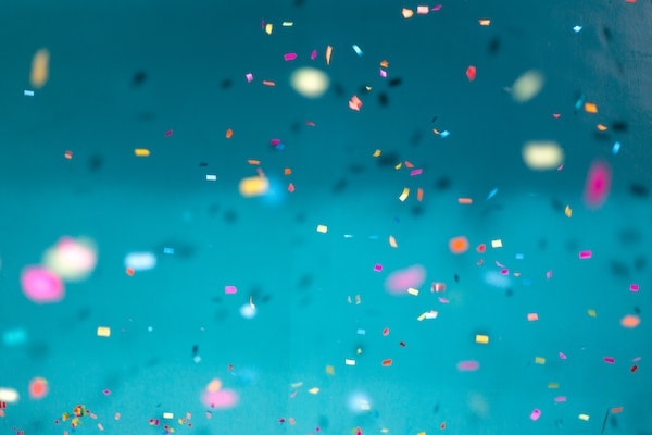 falling confetti against a teal background